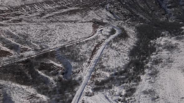 Aerial View of a Snowy Curve Country Road