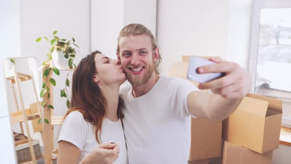 Happy Caucasian Pair Making Selfie with Keys From New Flat in Slowmotion