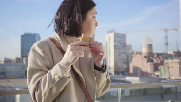 Portrait of Young Brunette Caucasian Woman Eating Hungrily Sandwich. Successful Businesslady Having