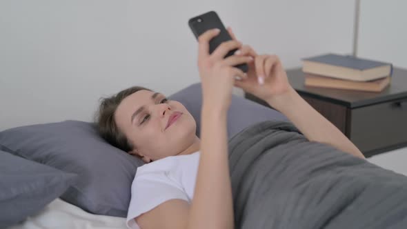 Woman Using Smartphone While Sleeping in Bed