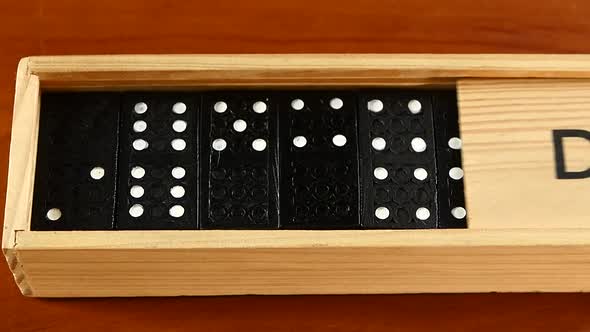 Domino Game in Open and Closed Box, Isolated on Wooden Surface, Slow Motion