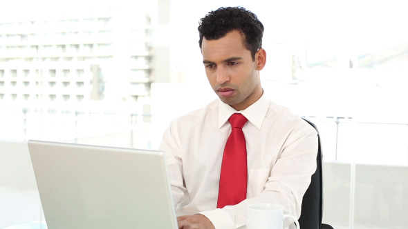 Smiling Handsome Businessman Typing On Laptop