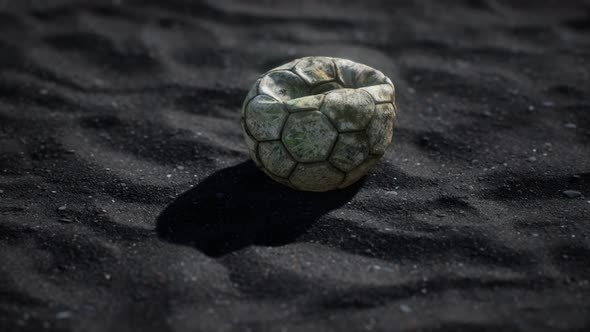 Old Football Ball on the Black Sand