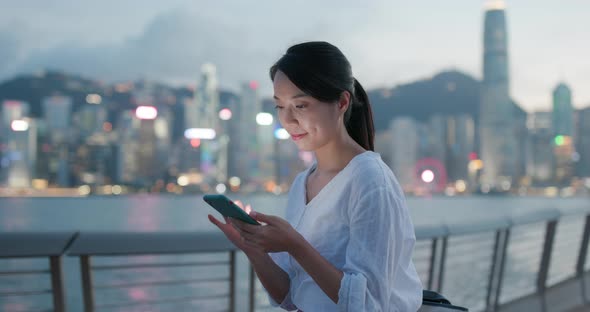 Asian woman use of mobile phone in city at night