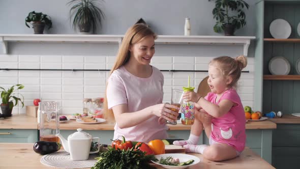 Beautiful Mother Cooking Dinner on Kitchen with Little Kid