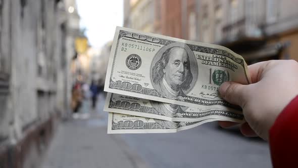 Three Hundred Dollar Bills on Blurred Background of European Street