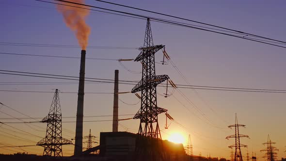 Electricity pylons and lines at dusk. Silhouette of high voltage tower and wires