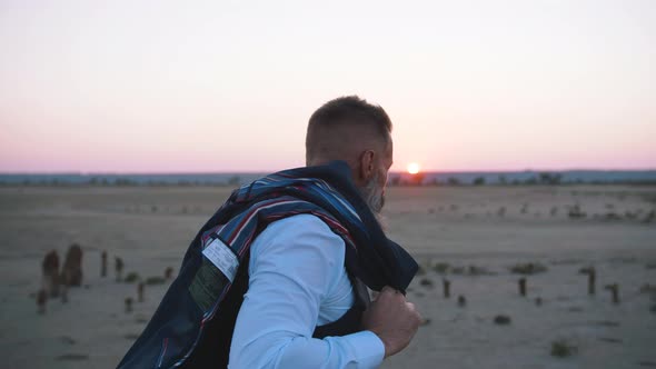 Handsome Bearded Mature Man in Suit Walking Outdoors on Beach During Sunset Slow Motion