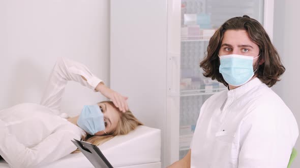 Male Doctor Wearing Face Mask Discussing with Woman Patient While Appointment in the Office at the