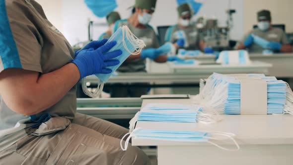 Several Factory Workers Stretching and Packing Face Masks at a Medical Mask Manufacturing Facility