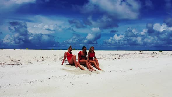 Tourists posing on perfect shore beach voyage by aqua blue water with white sandy background of the 