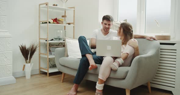 In the Modern Living Room Couple Using a Notebook