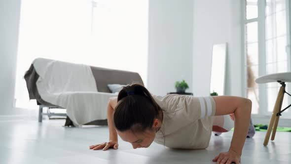 The Girl Performs Pushups From the Floor