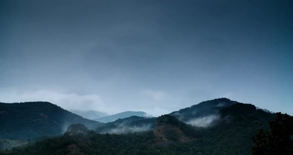 Haze of Stratus Clouds Dissolves Between the Mountains on a Cloudy Evening