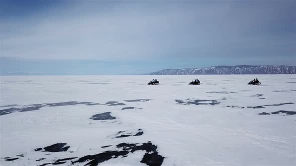 Aerial View Snowmobiles Ride on the Frozen Lake Baikal in Winter