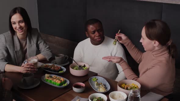 Girl Feeding African American Man Sushi
