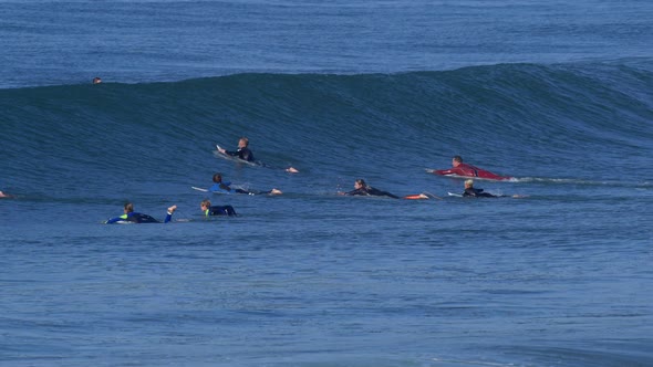 A crowded lineup of surfers surfing.
