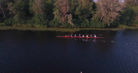 Sports Canoe Driven By Team Men Women Sailing Along Calm River with Sun