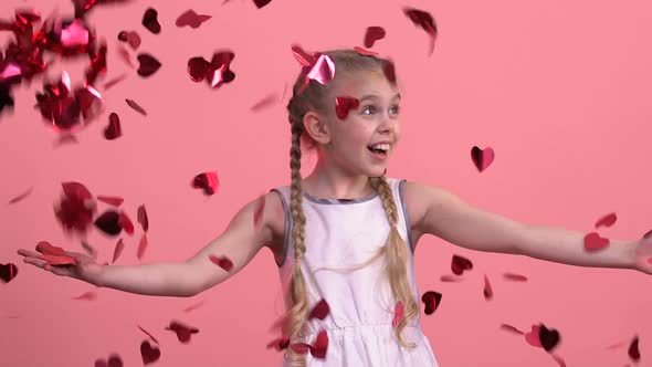 Excited Girl Enjoying Fallen From Sky Heart-Shaped Confetti, Fest Celebration