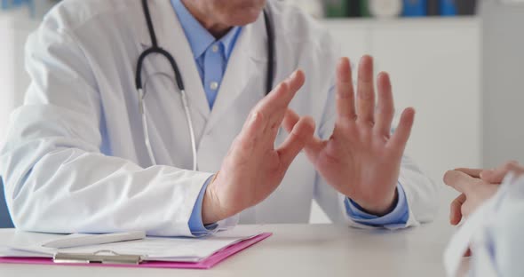 Close Up of Patient and Doctor Hands in Medical Office on Table