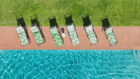 Aerial Zoom in Shot Perfect Swimming Pool Sun Reflection on Blue Water Surface