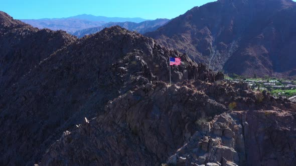 Aerial Drone Shot of American Flag with Mountain Range Background