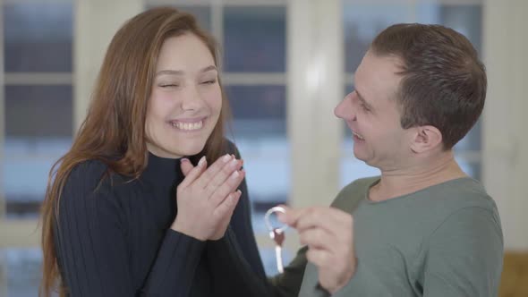 Portrait of a Happy Married Couple Showing the Keys of a Purchased New House or Apartment