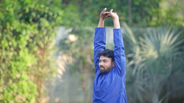 Indian man doing Upward Hand Stretch Yoga Pose or Urdhva Hastasana in Kurta Pajama