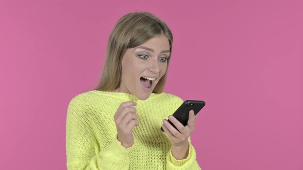 Excited Girl Cheering Success While Using Smartphone, Pink Background