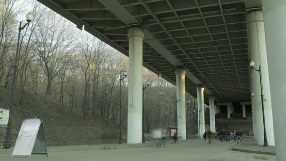 People in blur walking under the bridge