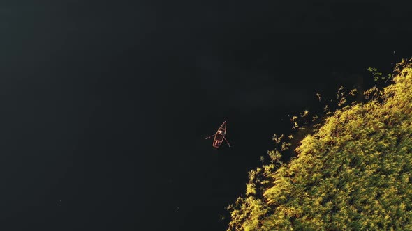 Top View Aerial Background Shot of Two People Rowing Small Boat on Idyllic Still Summer Morning Lake