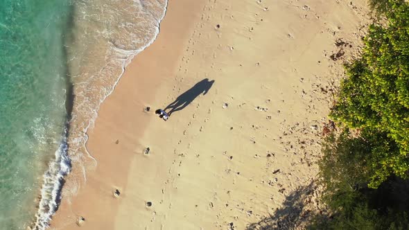 Young couple sunbathing on beautiful coastline beach time by clear water and white sand background o