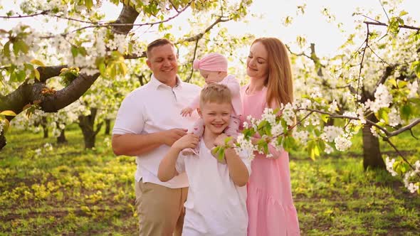 Family with Son and Daughter in Spring Flowering Garden