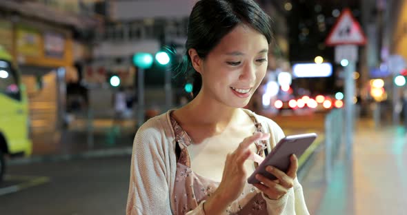 Woman use of smart phone in the city at night