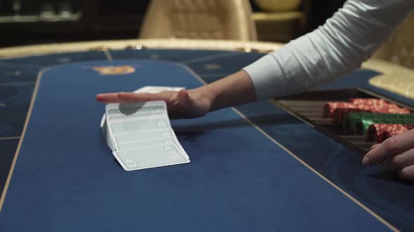 Dealer Beautifully Lays Out Cards on the Card Table in the Casino