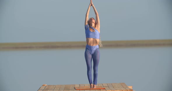 Pretty Woman Wearing Blue Sportswear is Exercising and Doing Yoga Poses