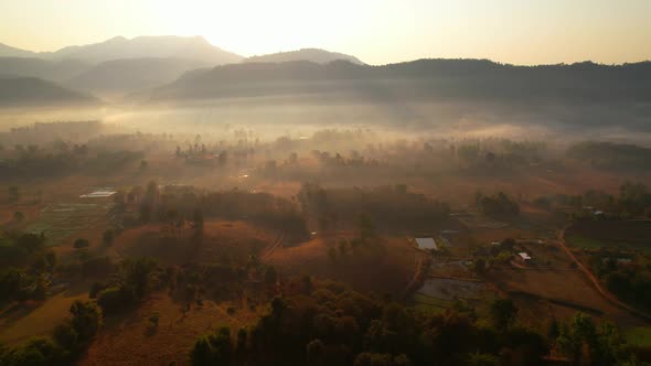 Aerial view from a drone over misty landscape on farmland. 4K