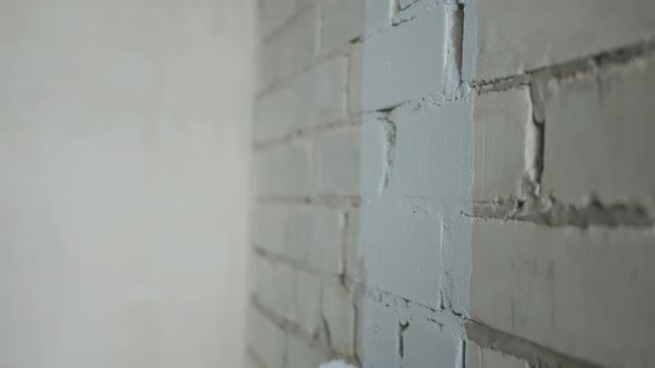 African-American Man Painting Brick Wall