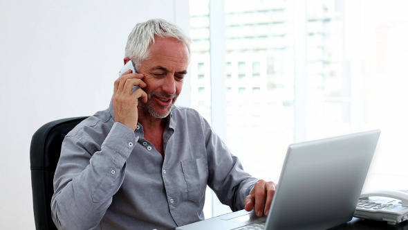 Casual Businessman Working On Laptop And Talking