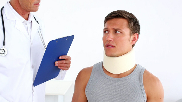 Sportsman In Neck Brace Being Checked By Doctor