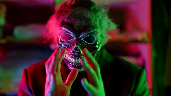 Halloween Party Concept Gloomy Man with Glowing Face Mask of Skull Exhaling Smoke or Steam