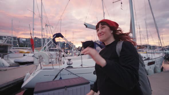 Woman Wearing a Hat Strolling Along the Shore at Sunset