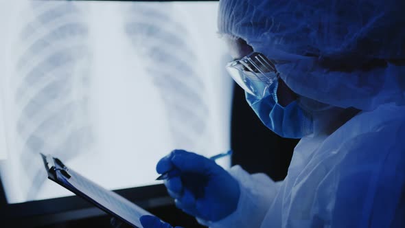 Doctor Works with an X-ray Photo of Lung Pneumonia