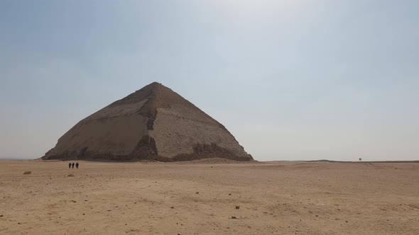 View of Ancient Sneferu Bent Pyramid at Dashur, people walk by the pyramid