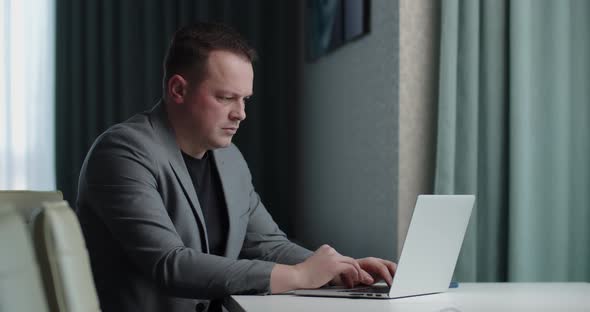 Man In Business Suit Working Online On Laptop