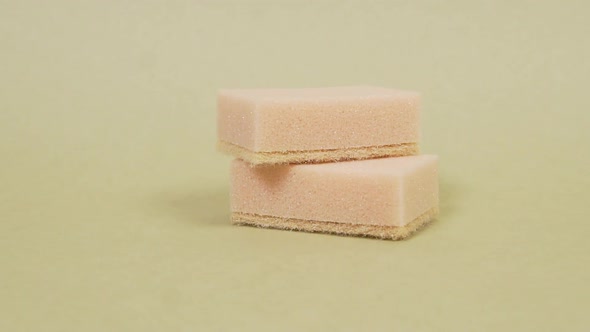 Two Sponges for Washing Dishes Lie on a Uniform Light Background