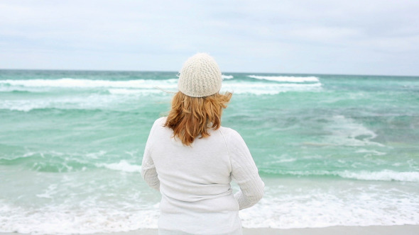 Retired Woman Spreading Her Arms On The Beach