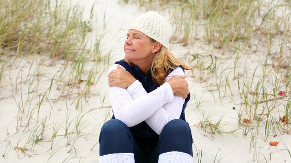 Retired Woman Sitting On The Beach