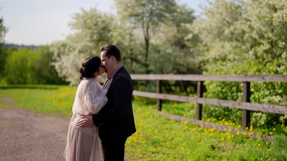 Beautiful Woman and Handsome Man are Kissing Outdoors in Sunny Summer Day Lovers are Walking