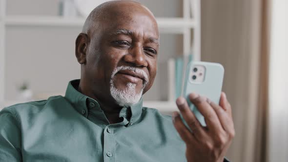 Senior Elderly 60s Businessman Sitting on Office Couch Has Video Call with Mobile App